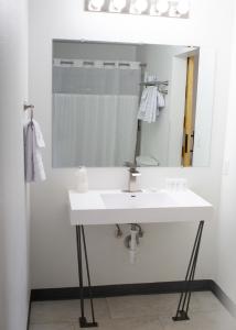 La salle de bains est pourvue d'un lavabo blanc et d'un miroir. dans l'établissement The Sage Motel, à Saratoga