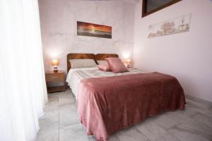 una camera da letto con un letto con due cuscini rosa di Etna Sea House a Catania