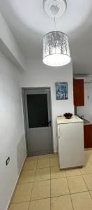 een keuken met een koelkast en een kroonluchter bij Tourists Guest House in Gjirokastër