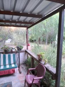 un porche cubierto con 2 sillas y una mesa en Casa en Costa Azul - Canelones, en La Floresta