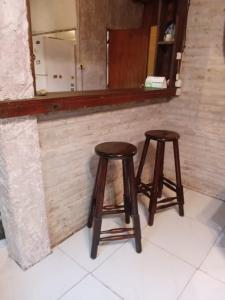 dos taburetes de madera sentados frente a un espejo en Casa en Costa Azul - Canelones, en La Floresta