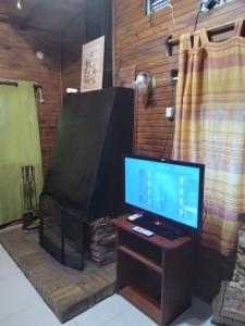 un televisor sentado en una mesa junto a una chimenea en Casa en Costa Azul - Canelones, en La Floresta