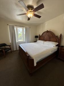 1 dormitorio con 1 cama grande y ventilador de techo en Hotel Coral Reef en Kapaa