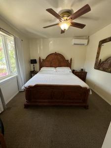 a bedroom with a large bed with a ceiling fan at Hotel Coral Reef in Kapaa