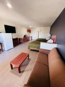 湄林的住宿－德克薩斯維多利亞套房汽車旅館，带沙发、床和电视的客厅