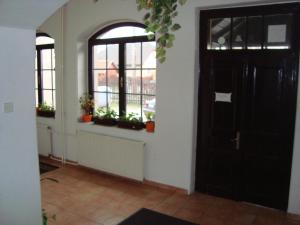 una habitación con una puerta negra y algunas ventanas en Penzion Adria, en Turčianske Teplice