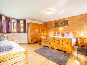 a bedroom with two beds and wooden walls at Chalet Anna in Bruck am Ziller