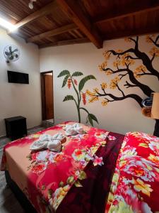 a bedroom with a bed with a tree mural on the wall at Hotel La Sultana in Jardin