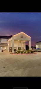 湄林的住宿－德克薩斯維多利亞套房汽車旅館，一座大型加油站,有照明的建筑