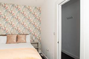 um quarto com uma cama com uma cabeceira floral em Charming and Bright 2 Bedroom Apartment, Close to Stadiums, Transport links, Free Parking em Manchester