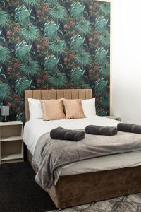 a bedroom with a bed with a tropical wallpaper at Charming and Bright 2 Bedroom Apartment, Close to Stadiums, Transport links, Free Parking in Manchester