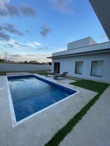 a swimming pool in front of a house at Casa de campo 1h30 de SP Ninho verde 1 in Porangaba