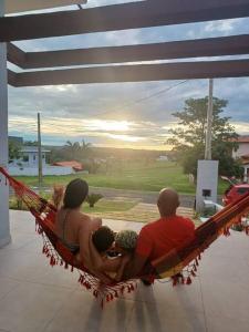 a group of people sitting in a hammock at Casa de campo 1h30 de SP Ninho verde 1 in Porangaba