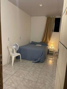 - une chambre avec un lit, une chaise et une fenêtre dans l'établissement Hostel Baltazar, à Fortaleza