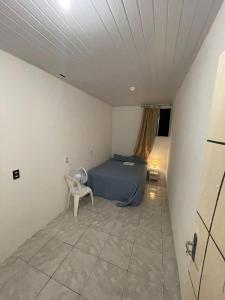 - une chambre avec un lit et une chaise dans l'établissement Hostel Baltazar, à Fortaleza