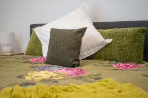 a bed with two pillows and flowers on it at Modern Stylish New 3 Mins CBD in Christchurch