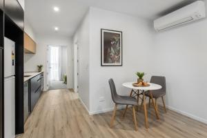 a kitchen and dining room with a table and chairs at Modern Stylish New 3 Mins CBD in Christchurch