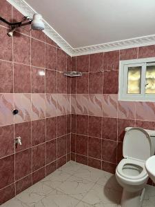 uma casa de banho com um WC e uma janela em 4 Rooms + Pool in private historic Villa em Mombasa