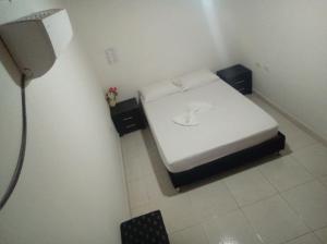 a small white bed in a small room at HOSTAL SARITA in Villavieja