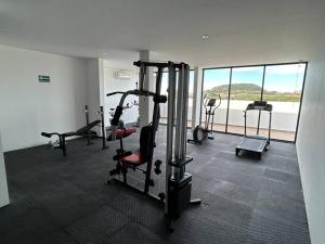 a gym with several tread machines and a large window at Loft Marina Cerritos in Mazatlán
