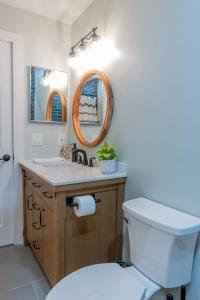 a bathroom with a toilet and a sink and a mirror at Stunning! Barefoot Breeze - Sale! New Waterfront Listing! Brand New Pool with Putting Green! in Bonita Springs