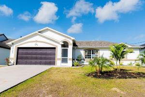 a white house with a garage at Stunning! Barefoot Breeze - Sale! New Waterfront Listing! Brand New Pool with Putting Green! in Bonita Springs