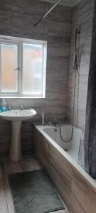 a bathroom with a tub and a sink and a bath tub at Greenwich Homestay in London
