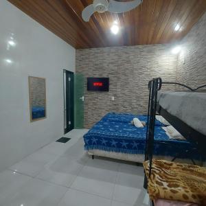 1 dormitorio con 1 cama y un cartel en la pared en Pousada Casa na Árvore en Mangaratiba