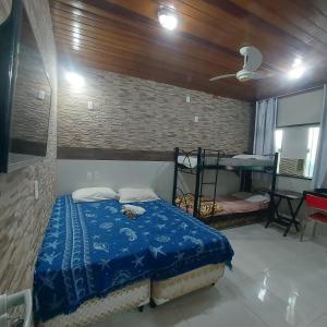 1 dormitorio con 1 cama con manta azul en Pousada Casa na Árvore en Mangaratiba