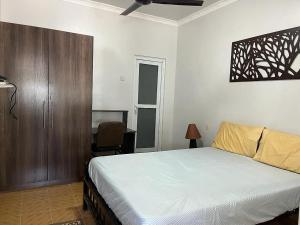 um quarto com uma cama, uma secretária e uma cadeira em 4 Rooms + Pool in private historic Villa em Mombasa