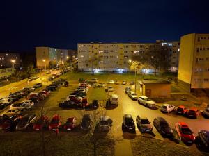 a parking lot with cars parked in it at night at Apartament Dworcowa in Konin