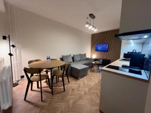 a kitchen and a living room with a table and a couch at Apartament Dworcowa in Konin