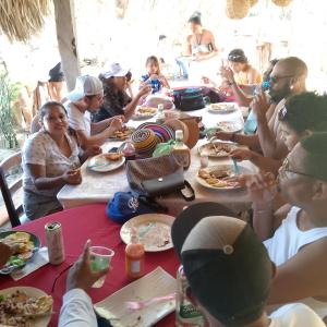 Altagracia的住宿－Beach cabin ometepe，一群坐在桌子旁吃食物的人