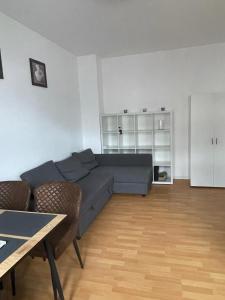 a living room with a blue couch and a table at A&A Apartments in Chemnitz