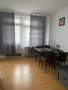 a living room with a table and chairs and a window at A&A Apartments in Chemnitz