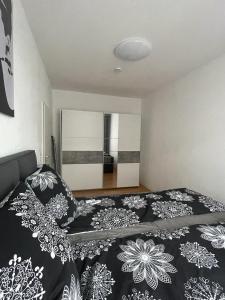 a bedroom with a bed with a black and white blanket at A&A Apartments in Chemnitz