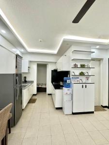a large kitchen with white cabinets and appliances at Caiden's Home in Davao City