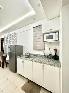 a kitchen with a sink and a refrigerator at Caiden's Home in Davao City