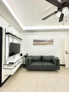 a living room with a couch and a flat screen tv at Caiden's Home in Davao City
