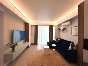 布加勒斯特的住宿－Interio Apartament PREMIUM in Cortina North，客厅配有蓝色的沙发和电视