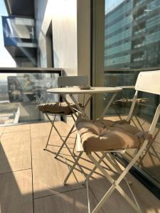 twee stoelen en een tafel voor een raam bij Interio Apartament PREMIUM in Cortina North in Boekarest