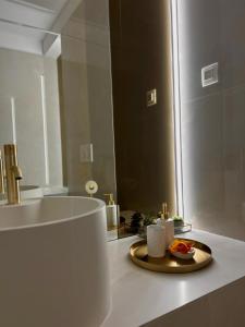 a bathroom with a sink and a plate of fruit on a counter at Interio Apartament PREMIUM in Cortina North in Bucharest