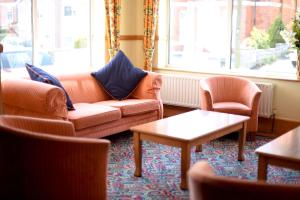 a living room with a couch and two chairs at The Riviera Hotel & Apartments - Alum Chine in Bournemouth