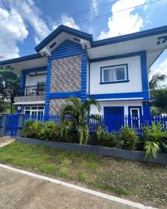 uma casa azul com uma cerca azul em Charlotte's Vacation Home Busuanga Palawan 