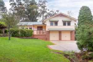 カトゥーンバにあるStunning Katoomba Home with Lush Garden&Playgroundの私道と芝生の庭のある家