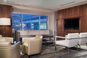 a living room with a couch and a tv and chairs at AC Hotel Chicago Downtown in Chicago