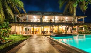 a villa with a swimming pool at night at Hotel Arc En Ciel in Dzamandzar