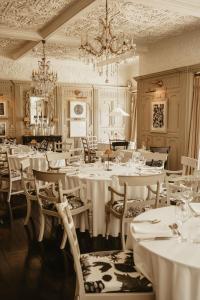 ein Restaurant mit weißen Tischen und Stühlen und einem Kronleuchter in der Unterkunft HIGHFIELD in Great Driffield