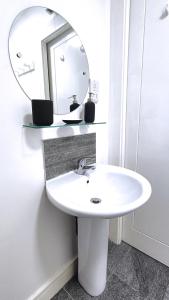 a bathroom with a white sink and a mirror at Charming and Bright 2 Bedroom Apartment, Close to Stadiums, Transport links, Free Parking in Manchester