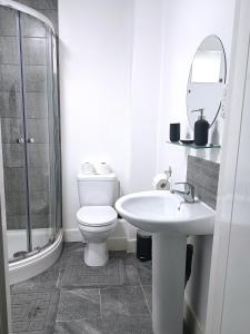 Charming and Bright 2 Bedroom Apartment, Close to Stadiums, Transport links, Free Parking في مانشستر: حمام ابيض مع مرحاض ومغسلة